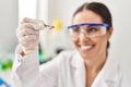 Young beautiful hispanic woman scientist smiling confident holding pill at laboratory Royalty Free Stock Photo