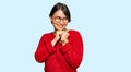 Young beautiful hispanic woman with short hair wearing casual sweater and glasses laughing nervous and excited with hands on chin Royalty Free Stock Photo