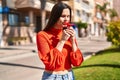 Young beautiful hispanic woman smelling flower at street Royalty Free Stock Photo