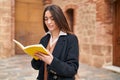 Young beautiful hispanic woman smiling confident reading book at street Royalty Free Stock Photo