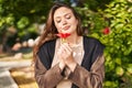 Young beautiful hispanic woman smiling confident smelling flower at park Royalty Free Stock Photo