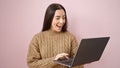 Young beautiful hispanic woman smiling confident using laptop over isolated pink background Royalty Free Stock Photo