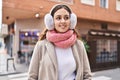 Young beautiful hispanic woman smiling confident wearing scarf and earmuff at street Royalty Free Stock Photo