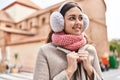 Young beautiful hispanic woman smiling confident wearing scarf and earmuff at street Royalty Free Stock Photo
