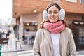 Young beautiful hispanic woman smiling confident wearing scarf and earmuff at street Royalty Free Stock Photo