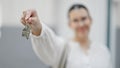 Young beautiful hispanic woman smiling holding new house keys at new house front door Royalty Free Stock Photo