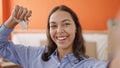 Young beautiful hispanic woman smiling holding new house keys taking selfie at new home Royalty Free Stock Photo