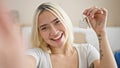 Young beautiful hispanic woman smiling holding new house keys taking selfie at new home Royalty Free Stock Photo