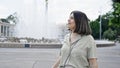 Young beautiful hispanic woman smiling looking around at Vienna fountain