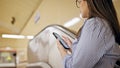 Young beautiful hispanic woman standing on escalator using smartphone in subway station of Madrid Royalty Free Stock Photo