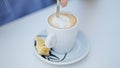 Young beautiful hispanic woman stir the coffee sitting on table at coffee shop terrace Royalty Free Stock Photo