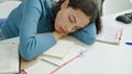 Young beautiful hispanic woman student sleeping on the desk at university classroom Royalty Free Stock Photo