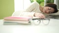 Young beautiful hispanic woman student sleeping on table at home Royalty Free Stock Photo