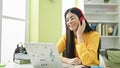 Young beautiful hispanic woman student using computer wearing headphones at library university Royalty Free Stock Photo