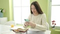 Young beautiful hispanic woman student using smartphone studying at home Royalty Free Stock Photo