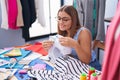 Young beautiful hispanic woman tailor smiling confident using sewing machine at tailor shop Royalty Free Stock Photo