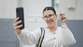 Young beautiful hispanic woman taking a picture showing keys at new house front door Royalty Free Stock Photo