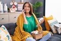 Young beautiful hispanic woman talking on smartphone holding pills of delivery package at home Royalty Free Stock Photo