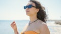 Young beautiful hispanic woman tourist wearing bikini standing with serious expression at beach Royalty Free Stock Photo