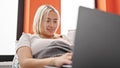 Young beautiful hispanic woman using laptop lying on sofa at home Royalty Free Stock Photo