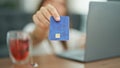 Young beautiful hispanic woman using laptop showing credit card sitting on floor at home Royalty Free Stock Photo