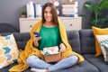 Young beautiful hispanic woman using smartphone holding pills of delivery package at home Royalty Free Stock Photo