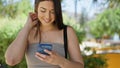 Young beautiful hispanic woman using smartphone smiling at park Royalty Free Stock Photo