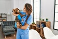 Young beautiful hispanic woman veterinarian smiling confident hugging dog at home Royalty Free Stock Photo