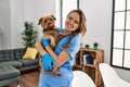 Young beautiful hispanic woman veterinarian smiling confident hugging dog at home Royalty Free Stock Photo