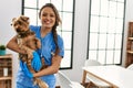 Young beautiful hispanic woman veterinarian smiling confident hugging dog at home Royalty Free Stock Photo