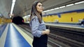 Young beautiful hispanic woman waiting for the subway using smartphone in subway station of Madrid Royalty Free Stock Photo