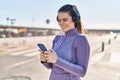 Young beautiful hispanic woman wearing sportswear listening to music at street Royalty Free Stock Photo