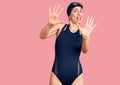 Young beautiful hispanic woman wearing swimwear and swimmer glasses afraid and terrified with fear expression stop gesture with