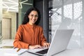 Young beautiful hispanic woman working inside modern office, businesswoman smiling and looking at camera at work using Royalty Free Stock Photo