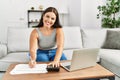 Young beautiful hispanic woman writing on document using calculator at home Royalty Free Stock Photo