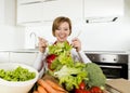 Young beautiful home cook woman at modern kitchen preparing vegetable salad bowl smiling happy Royalty Free Stock Photo