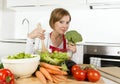 Young beautiful home cook woman at modern kitchen preparing vegetable salad bowl smiling happy Royalty Free Stock Photo