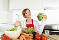 Young beautiful home cook woman at modern kitchen preparing vegetable salad bowl smiling happy Royalty Free Stock Photo