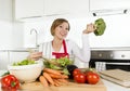 Young beautiful home cook woman at modern kitchen preparing vegetable salad bowl smiling happy Royalty Free Stock Photo