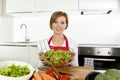 Young beautiful home cook woman at modern kitchen preparing vegetable salad bowl smiling happy Royalty Free Stock Photo