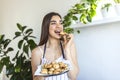 Young beautiful housewife holding freshly baked cookies on a tray in the kitchen Royalty Free Stock Photo