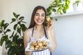 Young beautiful housewife holding freshly baked cookies on a tray in the kitchen Royalty Free Stock Photo