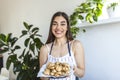 Young beautiful housewife holding freshly baked cookies on a tray in the kitchen Royalty Free Stock Photo