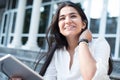 Young beautiful Indian girl, smiling, straightens her hair, holding a tablet in her hands. Lifestyle business girls Royalty Free Stock Photo