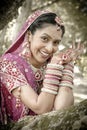 Young beautiful Indian Hindu bride laughing under tree with painted hands raised Royalty Free Stock Photo