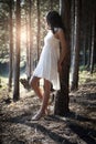 Young beautiful Indian woman leaning against tree in forest Royalty Free Stock Photo