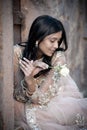 Young beautiful Indian Woman sitting against stone wall outdoors Royalty Free Stock Photo