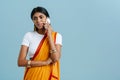 Young beautiful indian woman in traditional dress talking phone Royalty Free Stock Photo