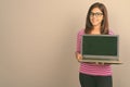 Young beautiful Indian woman wearing eyeglasses against gray background Royalty Free Stock Photo