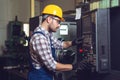 Industry Worker entering data in CNC machine at factory. Royalty Free Stock Photo